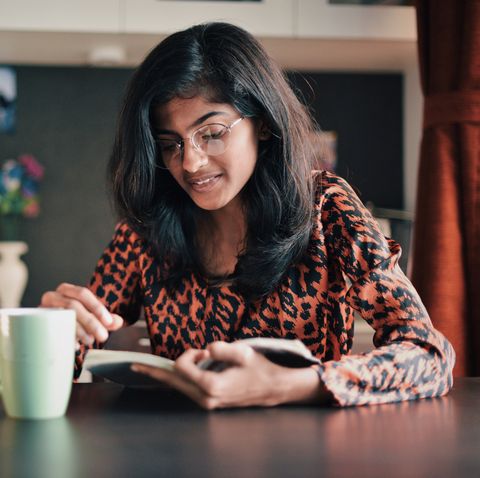 girl reading a book with a coffee mug- mental health during covid